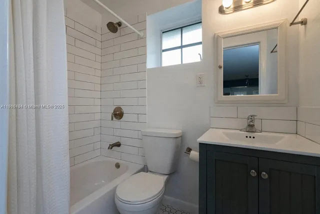 a bathroom with a toilet a sink a mirror and shower