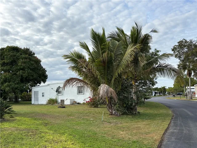 a view of house with garden and tall trees
