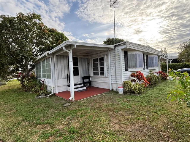 a view of a chair and table in backyard of the house