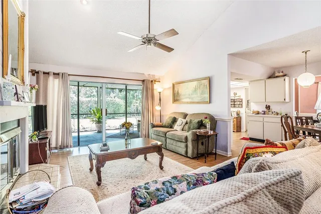 a living room with furniture and a dining table with kitchen appliances