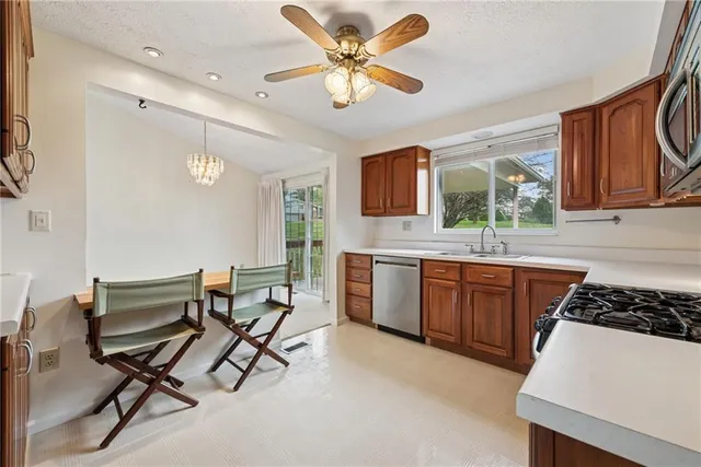 a kitchen with a table chairs a sink and appliances