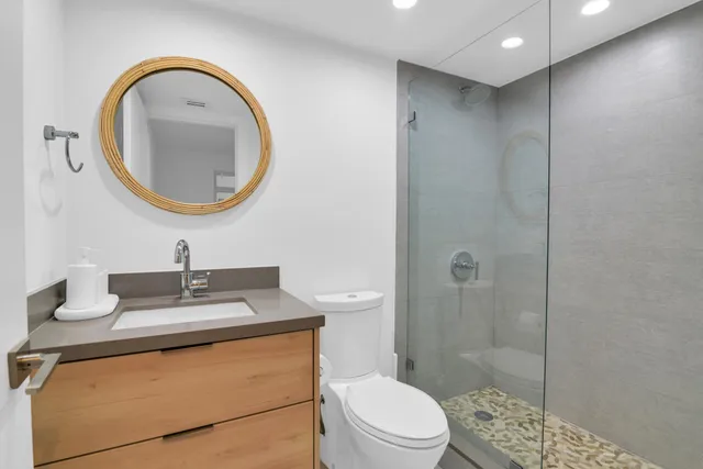 a bathroom with a sink a toilet and a mirror