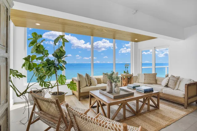 a living room with patio furniture and a potted plant