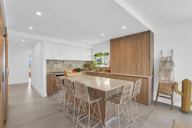 a kitchen with a dining table chairs and refrigerator