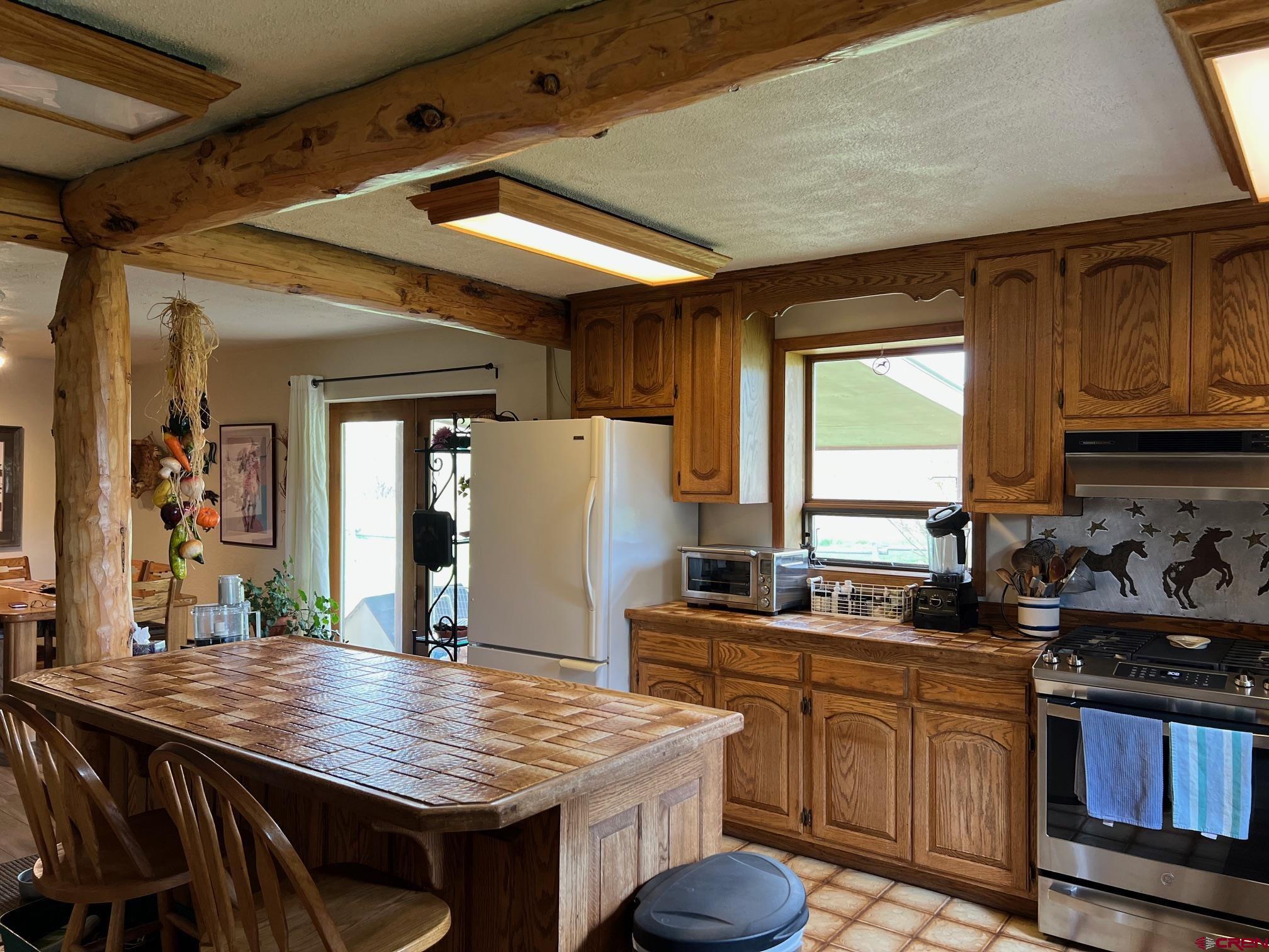 21446 Uncompahgre Road Montrose, CO 81403 - Photo 11 of 40 a kitchen with stainless steel appliances granite countertop a sink stove and refrigerator