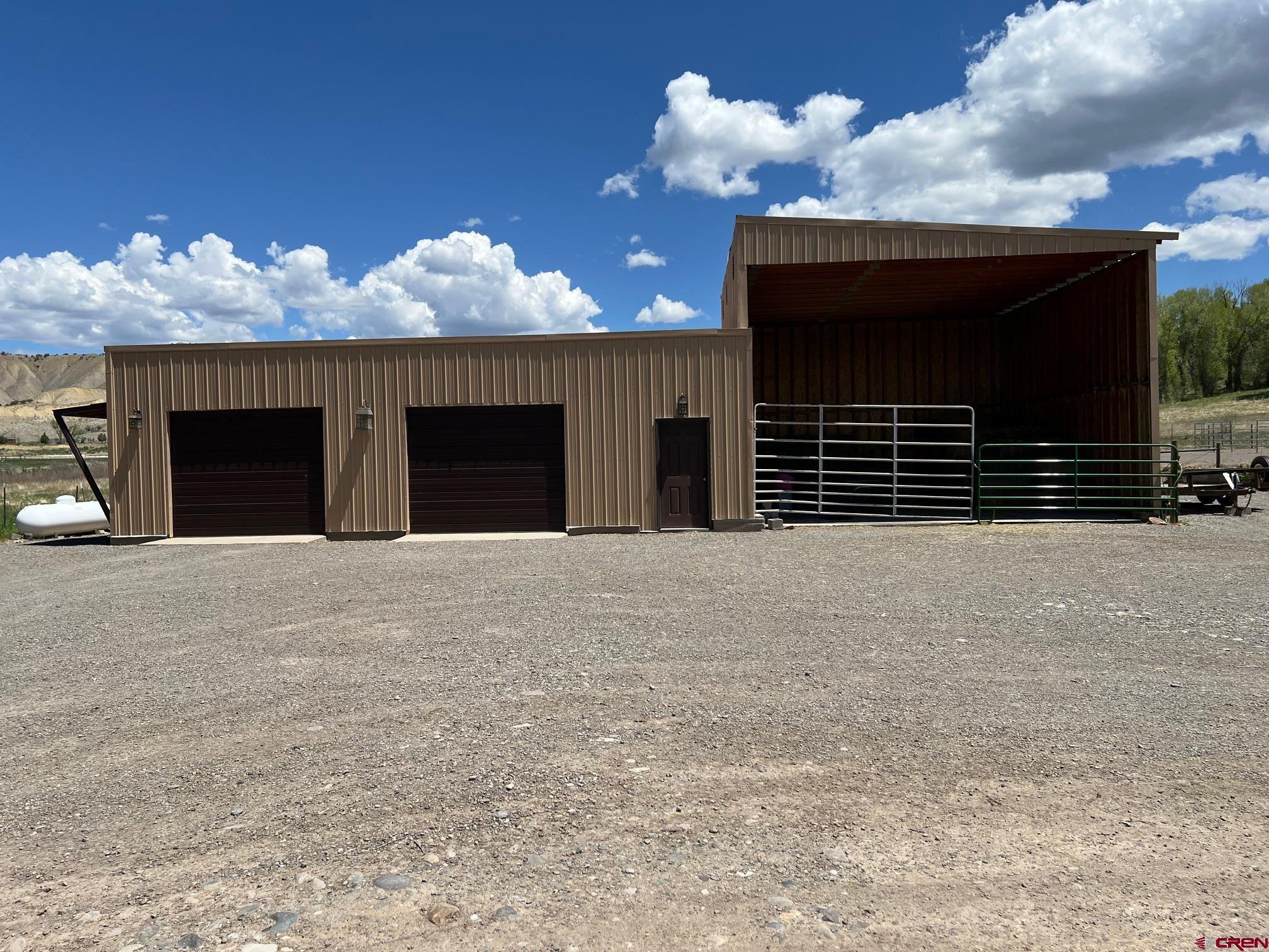 21446 Uncompahgre Road Montrose, CO 81403 - Photo 26 of 40 a front view of a house with a yard and garage