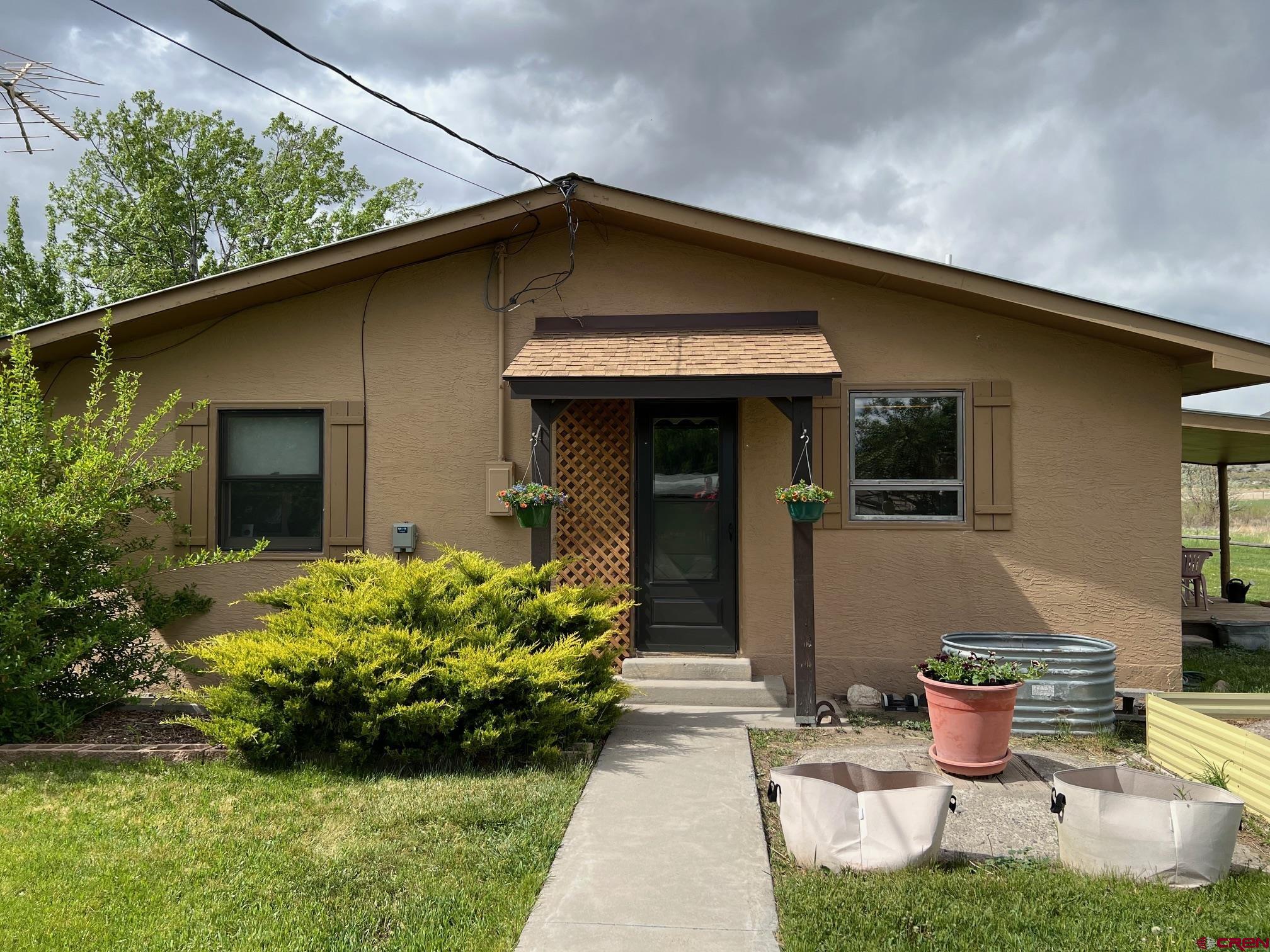 21446 Uncompahgre Road Montrose, CO 81403 - Photo 9 of 40 a front view of a house with garden