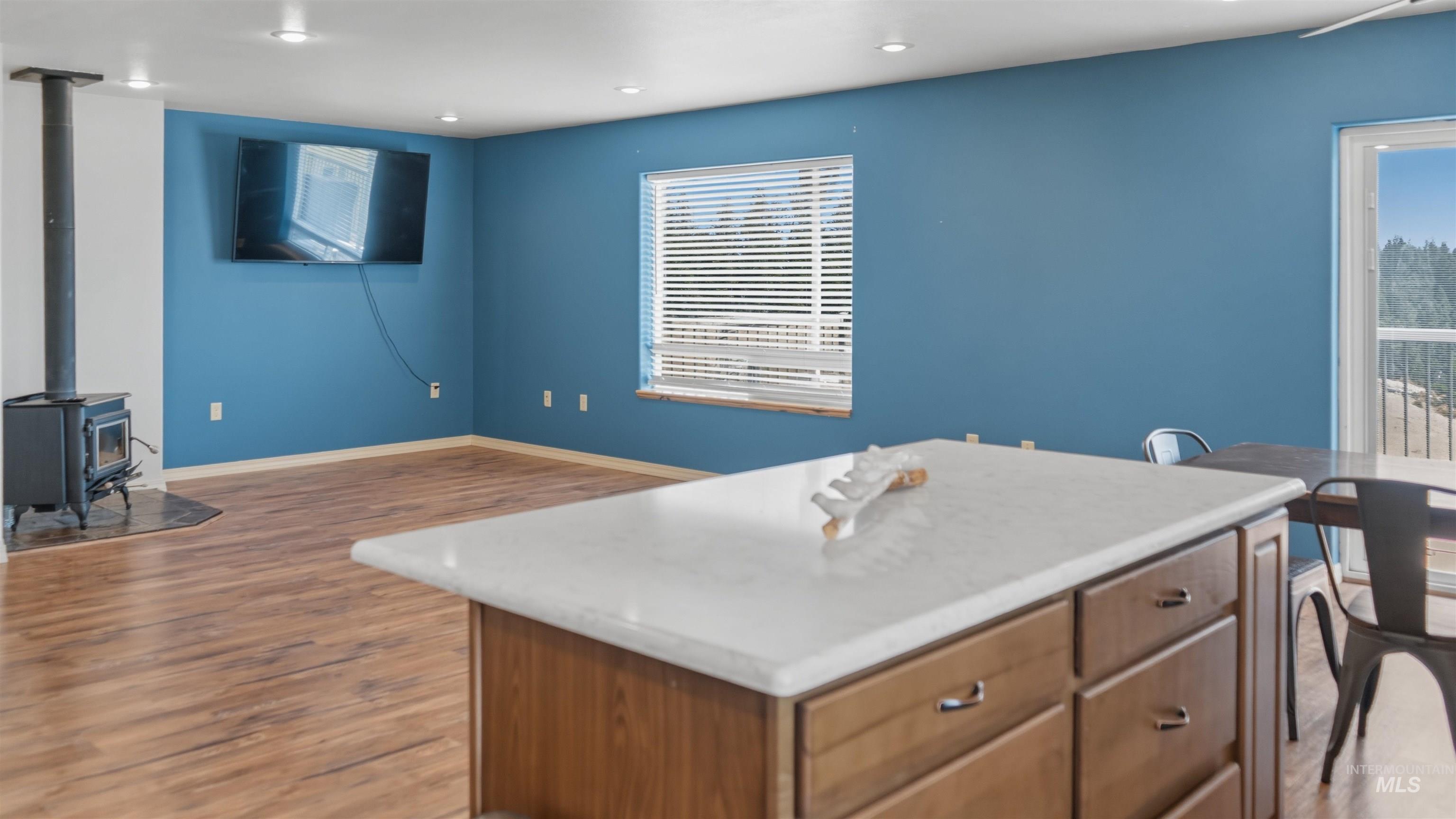 1028 Granlund Road Troy, ID 83871 - Photo 5 of 35 Open-concept living area featuring wood-finish flooring, recessed lighting, and a prominent wood stove