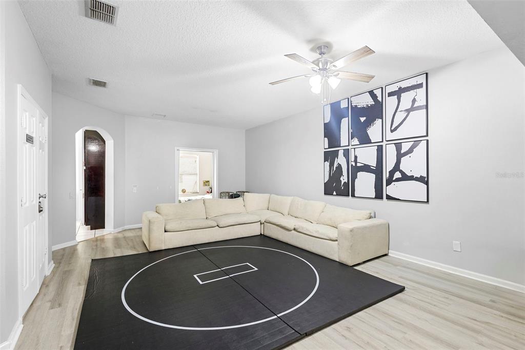 3111 River Branch Circle Kissimmee, FL 34741 - Photo 11 of 39 a living room with furniture and a chandelier