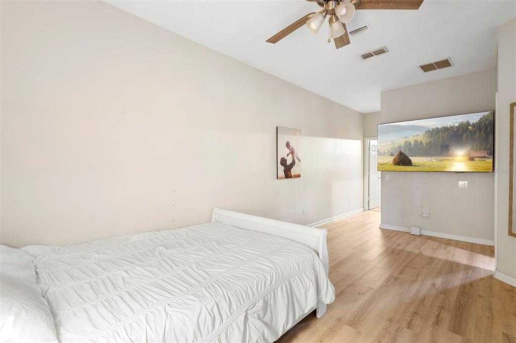 3111 River Branch Circle Kissimmee, FL 34741 - Photo 20 of 39 a bedroom with a large bed and a chandelier