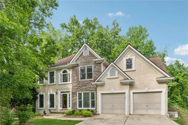 a view of a white house next to a yard