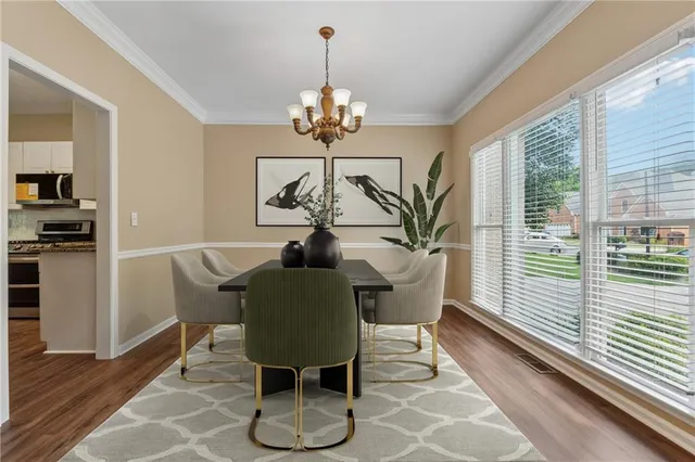 a dining room with furniture a large window and wooden floor