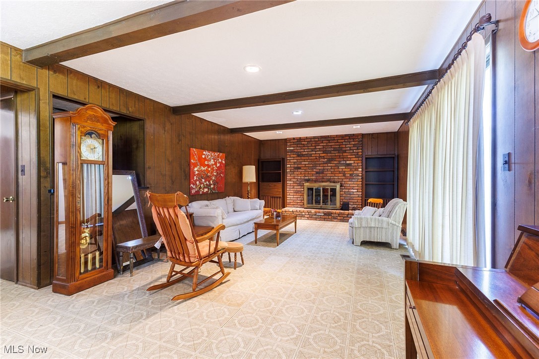 966 Brainard Road Cleveland, OH 44143 - Photo 18 of 50 Living room with wood walls, beamed ceiling, and a brick fireplace