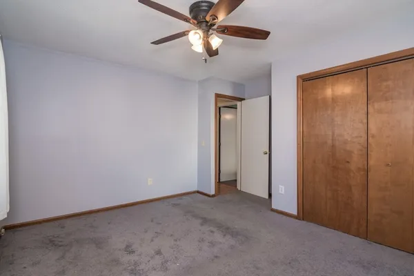 a view of an empty room and a ceiling fan