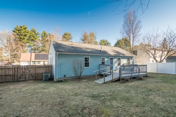 a view of a house with a backyard and a tree
