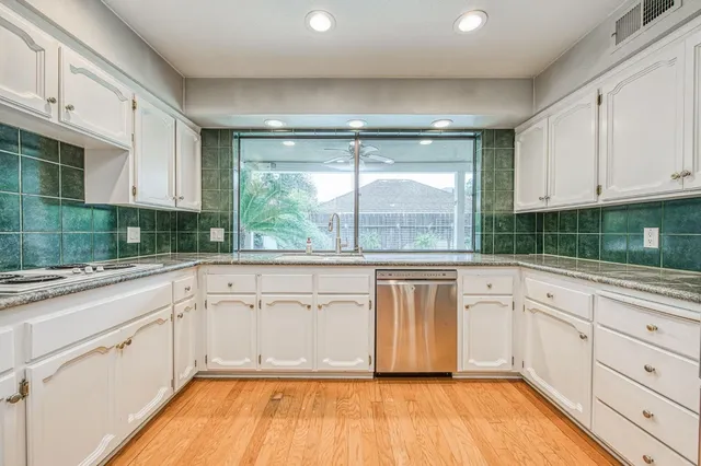 a kitchen with granite countertop white cabinets and white appliances