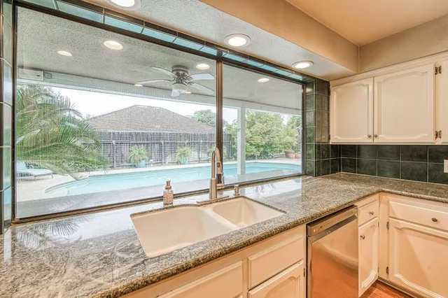 a kitchen with granite countertop sink and window