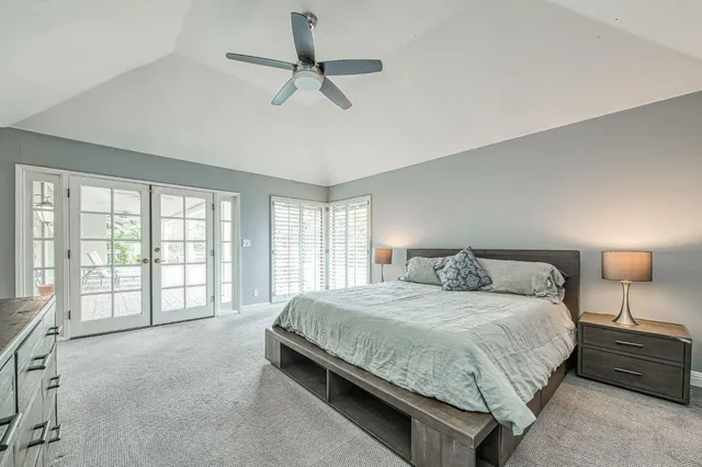 a bedroom with a large bed and a lamp on table