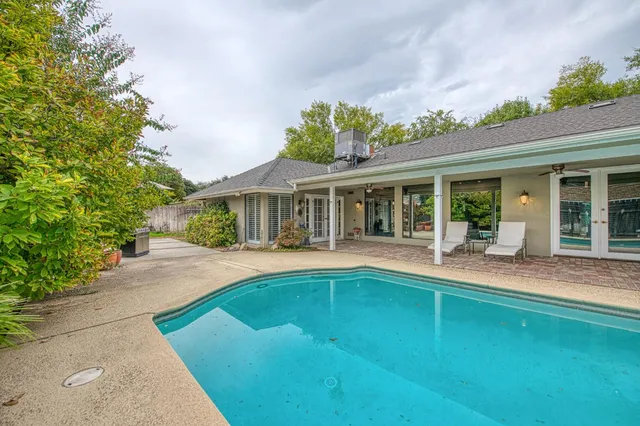 a view of house with swimming pool and glass windows