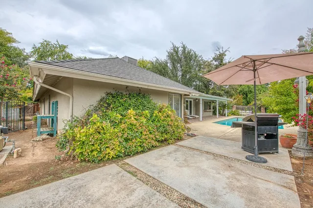 a view of a patio with table and chairs under an umbrella