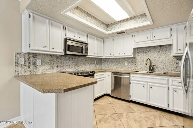 a kitchen with stainless steel appliances granite countertop a sink stove and microwave