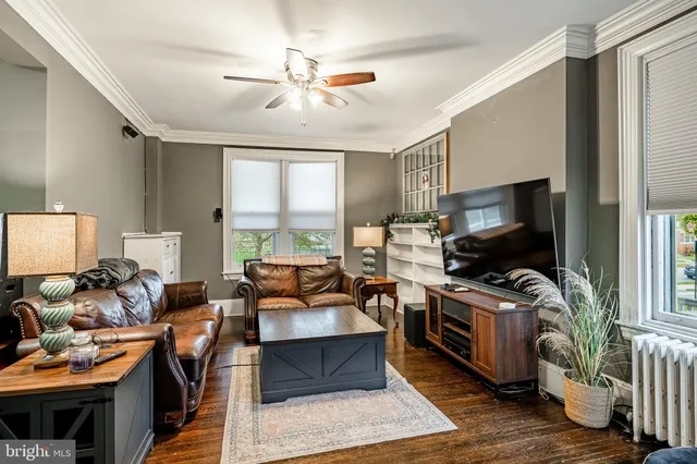 a living room with furniture a rug and a flat screen tv