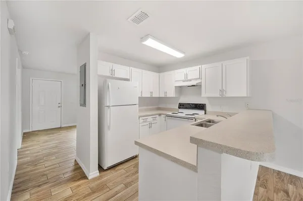 a kitchen with a sink a refrigerator and cabinets