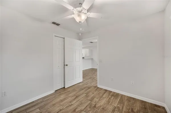 a view of a room with wooden floor and a ceiling fan