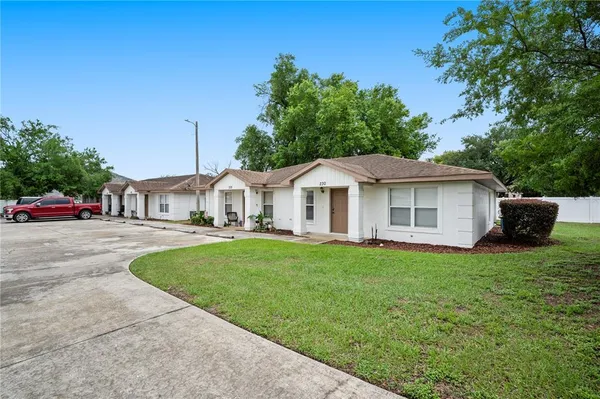 a front view of a house with cars parked