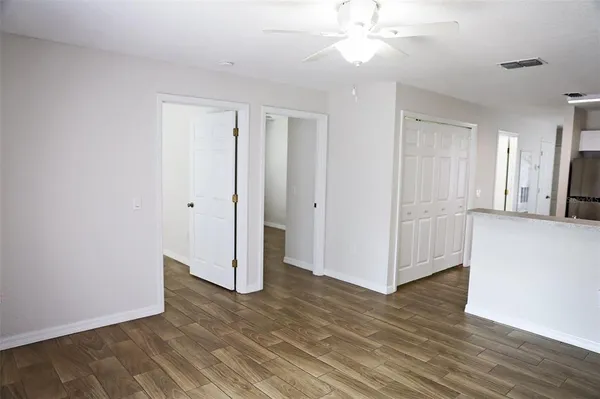 a view of an empty room with wooden floor and a window