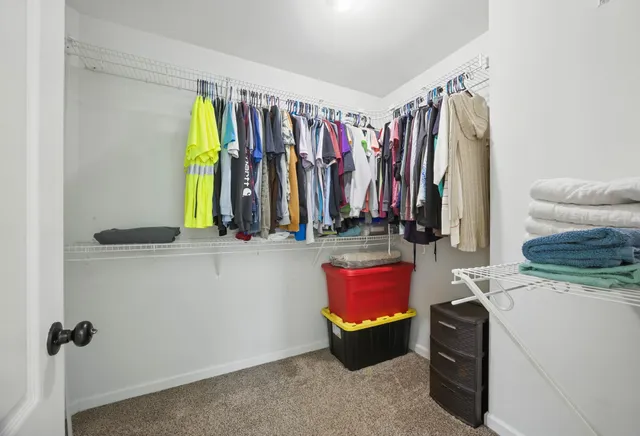 a view of walk in closet with clothes and shoes