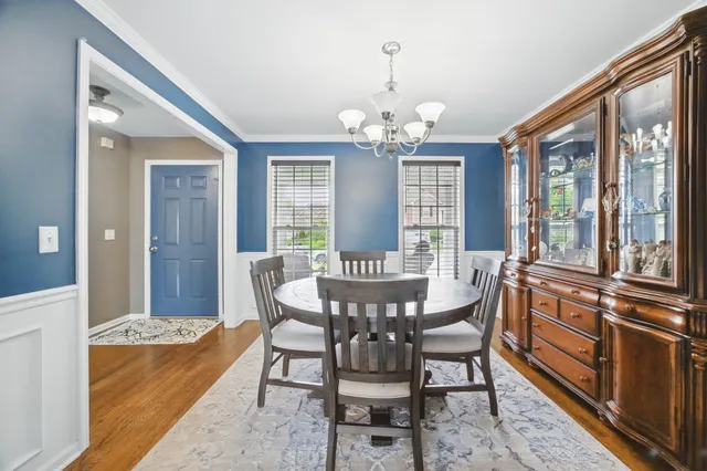 a view of a dining room with furniture a chandelier and wooden floor