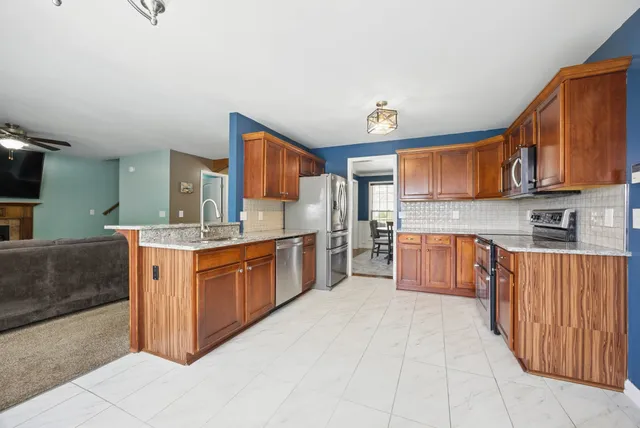 a large kitchen with stainless steel appliances granite countertop a stove a sink dishwasher and cabinets