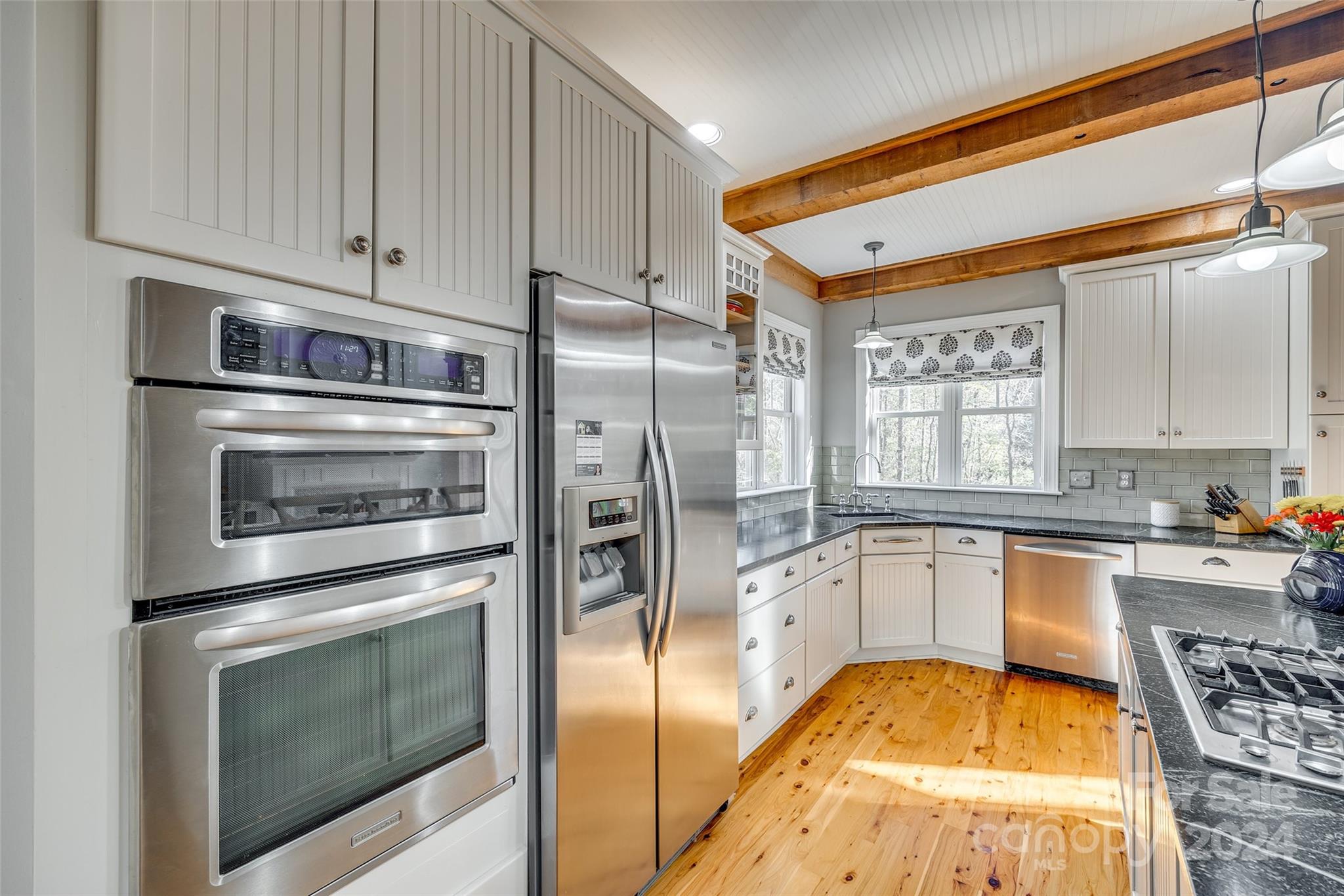 10621 Hanging Moss Trail Charlotte, NC 28227 - Photo 15 of 47 a kitchen with stainless steel appliances granite countertop a refrigerator a stove and white cabinets with wooden floor