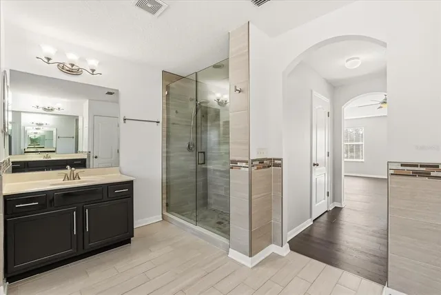 a spacious bathroom with a shower sink and mirror