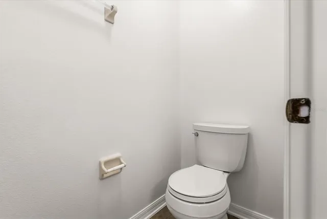 a white toilet sitting next to a white wall