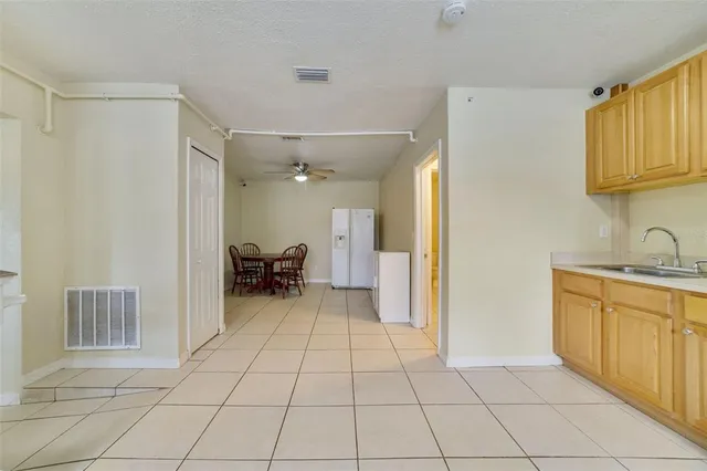 a kitchen with a refrigerator sink and cabinets