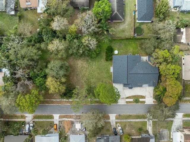 an aerial view of residential houses with outdoor space and trees