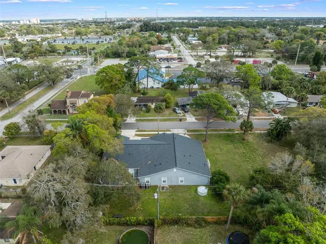 an aerial view of residential houses with outdoor space and trees