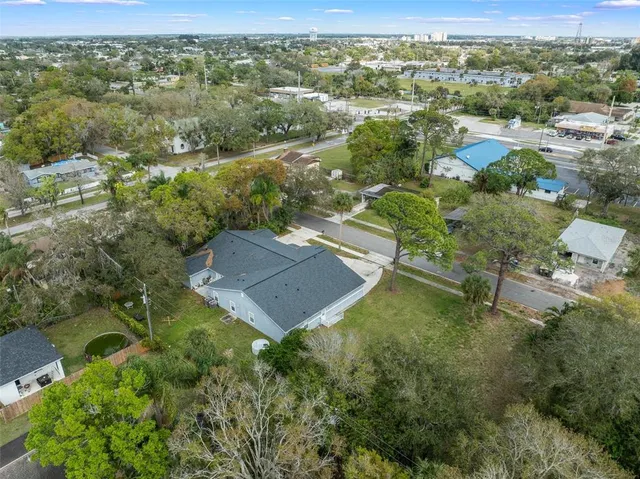 an aerial view of residential houses with outdoor space and trees