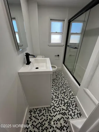 a bathroom with a sink toilet and window
