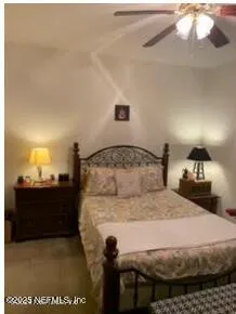a bedroom with a bed and teddy bear on bed