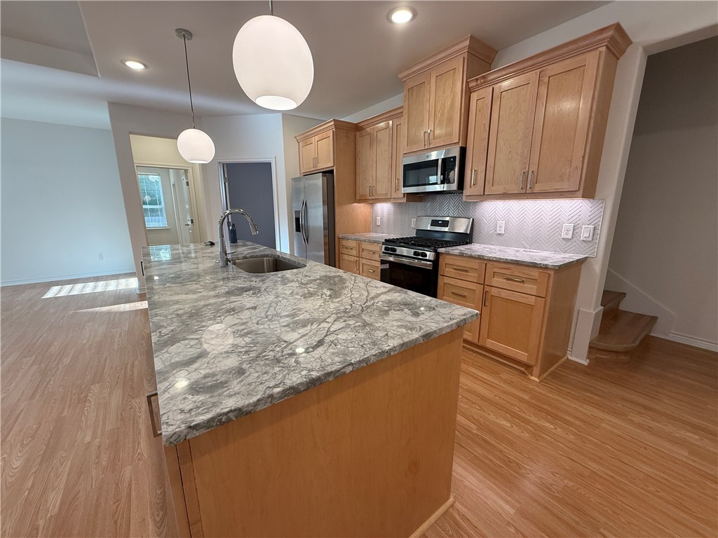 3533 Leesburg Path Bryan, TX 77808 - Photo 4 of 28 a kitchen with kitchen island granite countertop wooden cabinets a stove and a sink