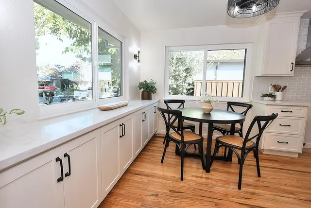 a kitchen with stainless steel appliances granite countertop a sink a stove and white cabinets
