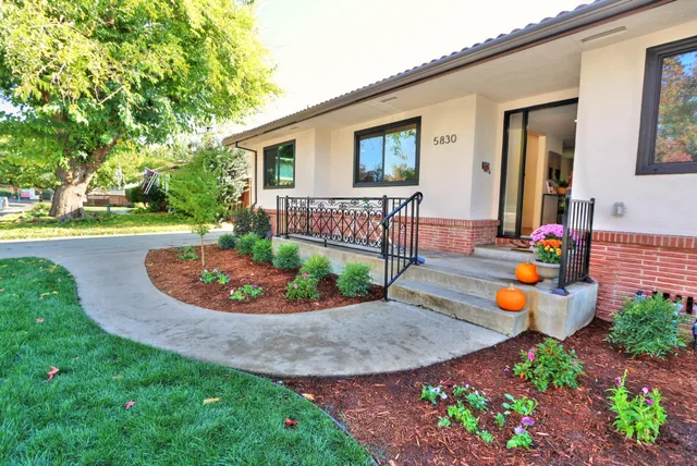 a dining room with wooden floor a chandelier a wooden table and chairs