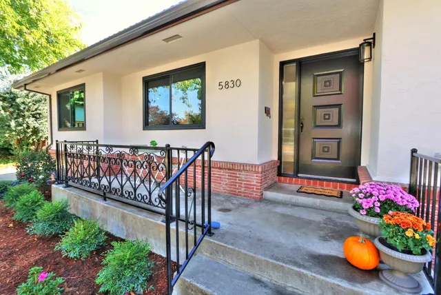 a dining room with wooden floor a chandelier a wooden table and chairs