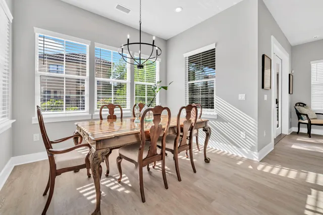 a view of a dining room with furniture a chandelier and wooden floor