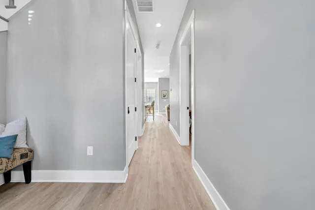 a view of a hallway with wooden floor and staircase
