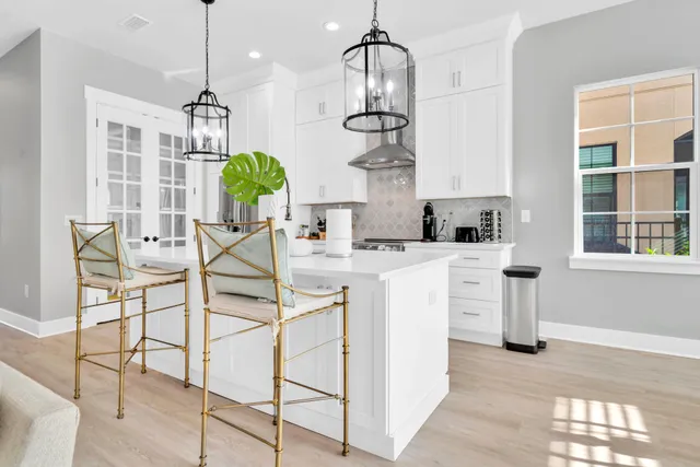a kitchen with stainless steel appliances a sink a chandelier and a counter top space