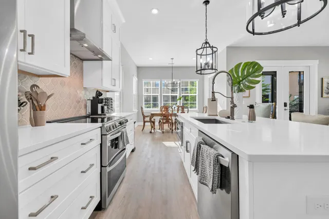 a kitchen with cabinets a sink a window and stainless steel appliances